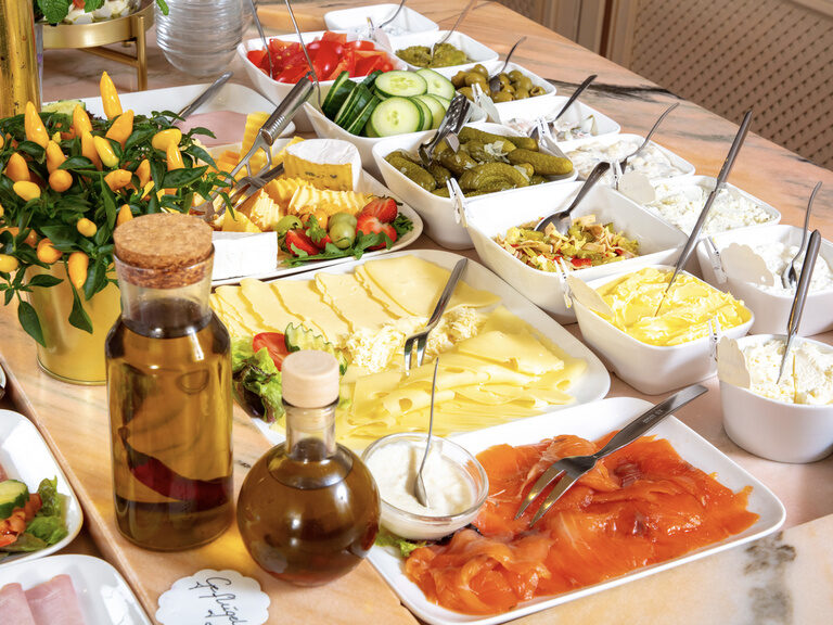 Ein schmackhaftes Buffet mit mehreren Salaten, Wurst und Käse.