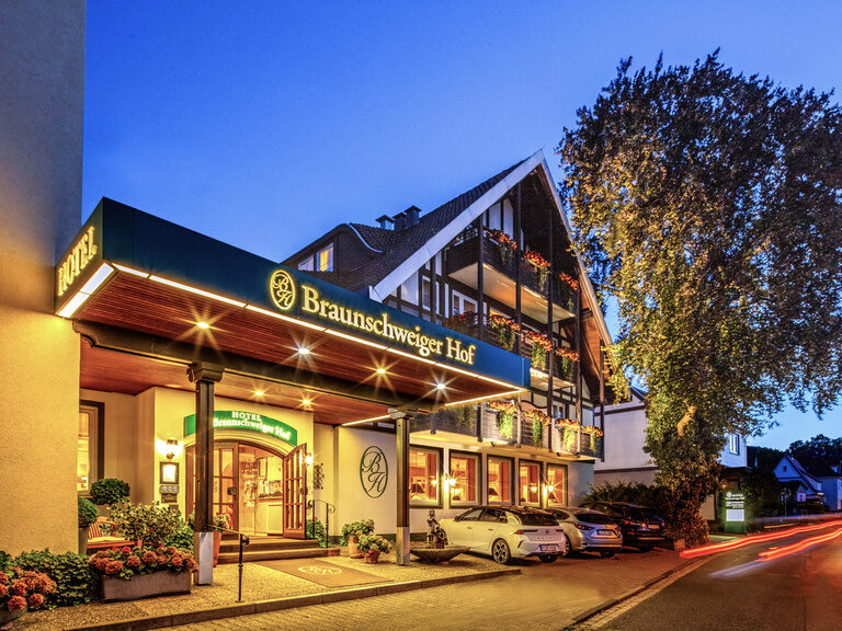 Das Hotel Braunschweiger Hof in warmem Licht bei Nacht.
